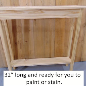 May include: A 32-inch long unfinished wooden console table with a shelf. The table is made of pine wood and is ready to be painted or stained.