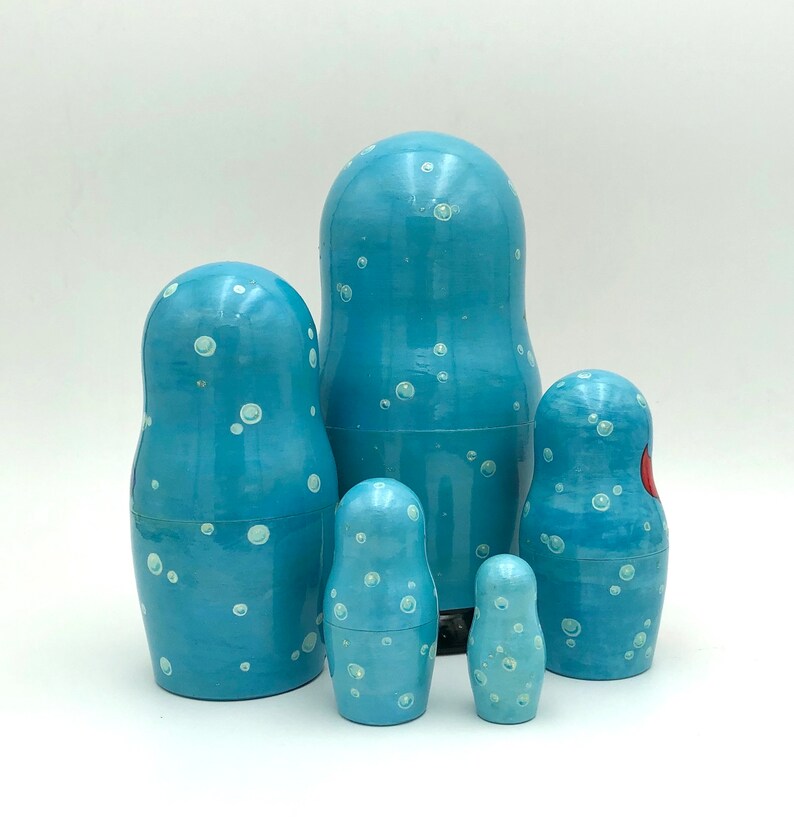 K&ouml;nnte beinhalten: Ein Satz von f&uuml;nf blauen und wei&szlig;en Nistpuppen, oder Matroschka-Puppen, mit einem wei&szlig;en Tupfenmuster. Die gr&ouml;&szlig;te Puppe ist die gr&ouml;&szlig;te und die kleinste Puppe ist die kleinste.
