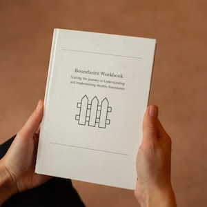 May include: A white workbook with the title "Boundaries Workbook" and the subtitle "Starting the Journey to Understanding and Implementing Healthy Boundaries". A black and white illustration of a fence is below the title.