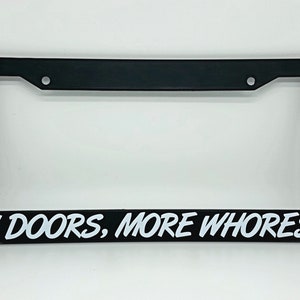 May include: Black license plate frame with white text that reads "4 DOORS, MORE WHORES".