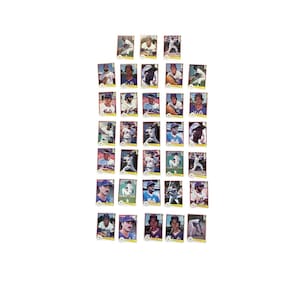 May include: A collection of vintage baseball cards featuring various players in action poses. The cards have a rectangular shape with player portraits and team logos. The cards are arranged in a grid pattern against a white background.