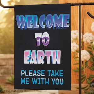 May include: A black garden flag with the text "Welcome to Earth Please Take Me With You" in a colourful, 3D-style font. The text is in a gradient of blue, purple, and pink.
