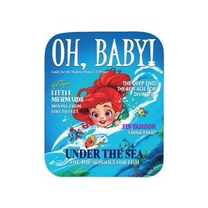 May include: A magazine cover featuring a cartoon mermaid on a blue background. The cover reads "Oh, Baby! Guide for the Modern Princess & Prince" and "Hot Topic: Little Mermaids Moving From Fins to Feet". The magazine also has the text "Under the Sea: The Top Schools for Fish".