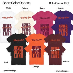 May include: A selection of t-shirts in various colours, featuring the text "Take My Hand" and "Never We're Off To Never Land". The t-shirts are available in white, natural, berry, purple, black, orange, maroon, and a light brown colour.