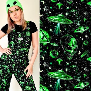 May include: Black and green overalls with a repeating pattern of green alien heads, spaceships, and planets on a black background.