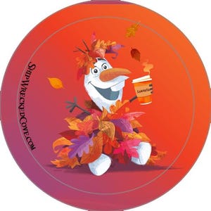 May include: A circular graphic featuring a white snowman character covered in autumn leaves, holding a coffee cup labeled Samantha. The background is a gradient of orange and red with falling leaves. The text SHIPWRECKEDCOVE.COM is printed on the left side.
