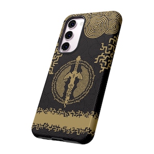 May include: Black phone case with a gold design featuring a sword and a circular pattern. The design includes a repeating pattern of stylized symbols.
