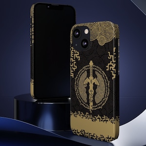 May include: Two iPhone cases, one black with a plain design and the other with a gold and black design featuring a sword and a circular pattern.