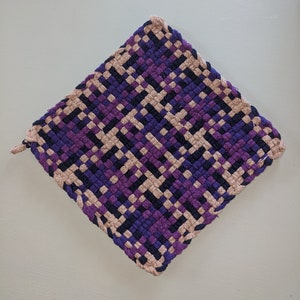 May include: A square woven pot holder with a checkered pattern in shades of purple, blue, and beige.