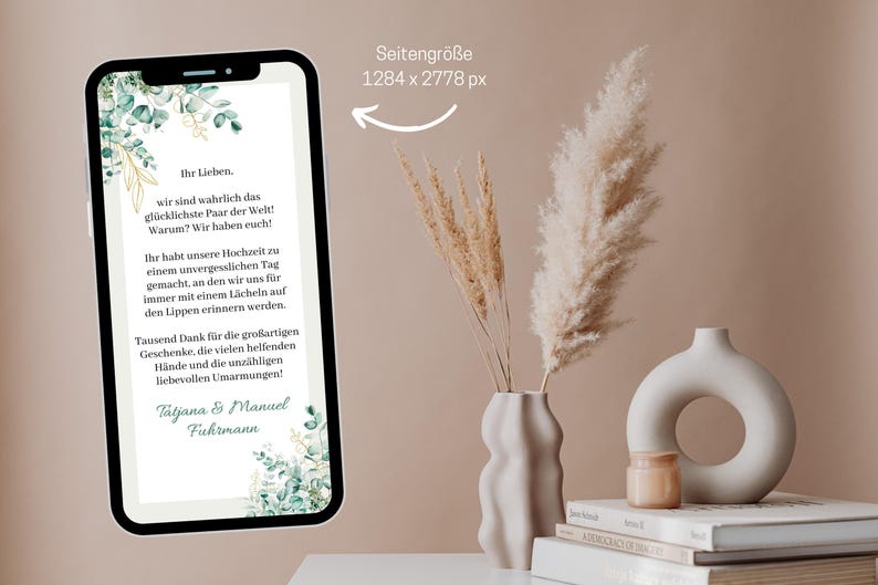May include: A digital phone screen displaying a wedding announcement with a green and gold floral design. The text reads "Ihr Lieben. wir sind wahrlich das gl&uuml;cklichste Paar der Welt! Warum? Wir haben euch!" and "Tausend Dank f&uuml;r die gro&szlig;artigen Geschenke, die vielen helfenden H&auml;nde und die unz&auml;hligen liebevollen Umarmungen! Tatjana & Manuel Fuhrmann".