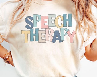 May include: A white t-shirt with the text "SPEECH THERAPY" in colorful, outlined letters. The letters are in different pastel colors, including pink, blue, yellow, and green.