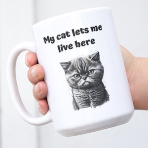 My Cat Lets Me Live Here Coffee Tea Mug Cup, 15oz Ceramic Cat Person Gift, Cat Lady Funny Cup, Grumpy Cat Lover, Sassy Cat Mom Dad by Mugzan