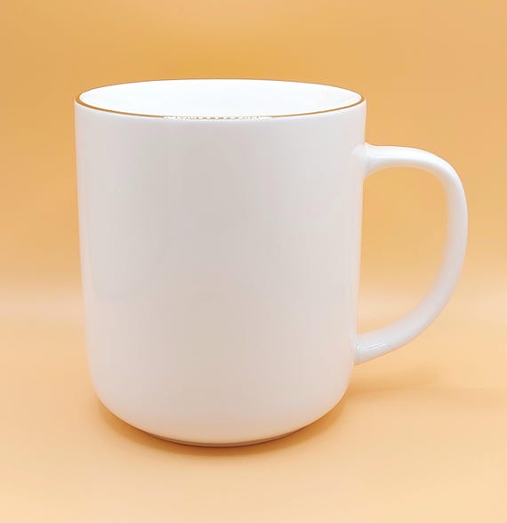 Elegante klassische weiße Keramik-Kaffeetasse: Goldener Griff, minimalistisches Trinkgefäß von Meritage