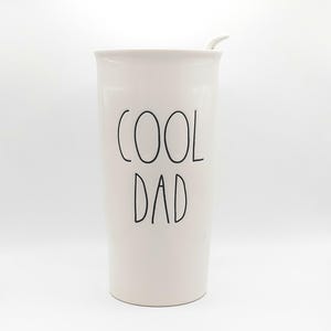 May include: White ceramic travel mug with a black lid and a black inscription that reads "COOL DAD".