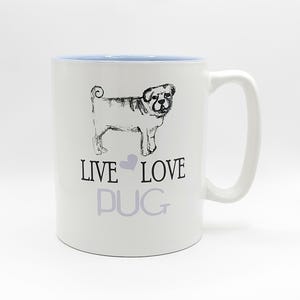 May include: White ceramic mug with a light blue interior and a white handle. The mug features a black and white sketch of a pug dog and the words "LIVE LOVE PUG" in black and gray.
