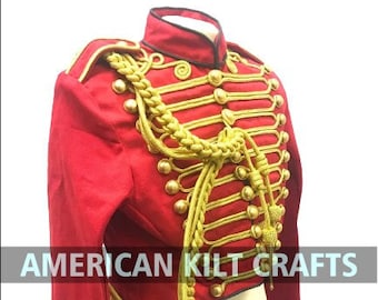 May include: A red military-style jacket with gold trim and buttons. The jacket has a long tail and is decorated with gold braid and tassels.