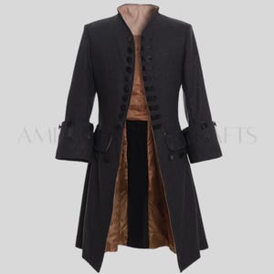 May include: A dark gray, long coat with a high collar and multiple buttons down the front. The coat has long sleeves with decorative cuffs and pockets. The interior lining is a contrasting tan color, and the coat appears to be made of a wool-like material.