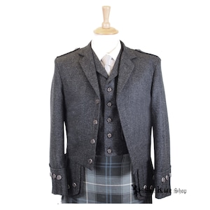 May include: A grey tweed kilt outfit with a matching jacket and waistcoat. The outfit features a kilt with a blue and green tartan pattern, a grey tweed jacket with a single-breasted closure, and a grey tweed waistcoat with a button-up front.
