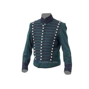 Puede incluir: Una chaqueta de estilo militar verde oscuro con ribetes negros y botones plateados. La chaqueta tiene un cuello alto y una silueta ajustada. "Scotland Kilt Shop" está impreso en la parte delantera de la chaqueta.
