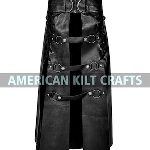 May include: Black leather kilt with a front slit and multiple straps and buckles. The kilt has a belt with a large metal buckle. "AMERICAN KILTCRAFTS" is printed on the front of the kilt.