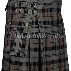 May include: A gray, black, and brown plaid kilt with a large cargo pocket on the front. The kilt has a buckle closure and is made of a woven fabric.