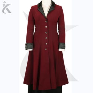 Peut inclure: Un long manteau bordeaux avec un col et des poignets en velours noir. Le manteau a une coupe ajustée, une rangée de boutons sur le devant et une jupe évasée. Les manches sont longues et les poignets sont noirs.