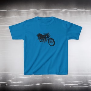 May include: A turquoise blue t-shirt featuring a black motorcycle graphic. The motorcycle design is a detailed silhouette, showcasing the bike's frame, wheels, and other components. The t-shirt is made of a soft material.