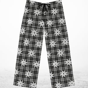 May include: Black and gray plaid pajama pants with a white sunburst pattern. The pants have a drawstring waist and a relaxed fit. The fabric appears to be soft and comfortable, suitable for lounging.