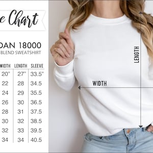 May include: A white Gildan 18000 heavy blend sweatshirt with a size chart. The chart shows measurements for sizes S to 5XL, including width, length, and sleeve length in inches. The sweatshirt is shown on a person.
