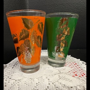 Coppia vintage di occhiali verdi e arancioni con design a uva e foglie dorate