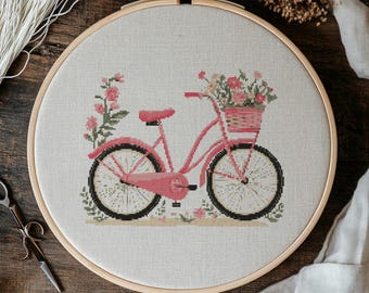 May include: A pink bicycle with a basket full of flowers. The bicycle is on a white background with a wooden frame.