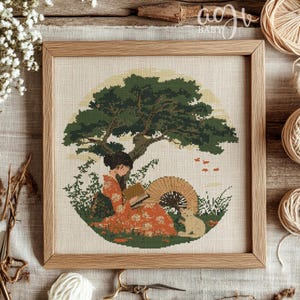 May include: Cross stitch pattern featuring a woman in a red and white kimono sitting under a green tree with a cat beside her. The woman is reading a book and there are small fish swimming in the sky.