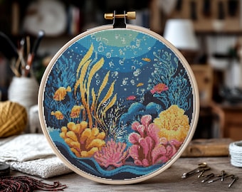 Könnte beinhalten: Ein Kreuzstich-Stickrahmen, der eine Unterwasser-Szene mit bunten Korallen, Algen und Fischen darstellt. Der Hintergrund ist dunkelblau mit Blasen.