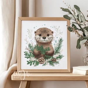 May include: A cross-stitch pattern featuring a cute otter holding a sprig of green leaves. The otter is surrounded by a wreath of green leaves, white flowers, and pine cones. The background is white with a subtle snow effect.