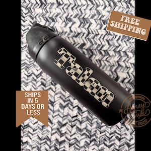 K&ouml;nnte beinhalten: Schwarze isolierte Wasserflasche mit einem karierten "Fabian" Design. Die Flasche hat einen schwarzen Deckel und einen schwarzen K&ouml;rper. Die Flasche liegt auf einer wei&szlig;-grau gemusterten Oberfl&auml;che.