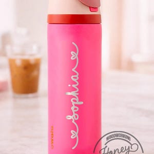 Op de afbeelding: Een felroze ge&iuml;soleerde waterfles met een lichtroze en rode deksel. De naam "Sophia" staat in een sierlijk lettertype op de zijkant. De fles heeft een inhoud van ongeveer 710 ml.