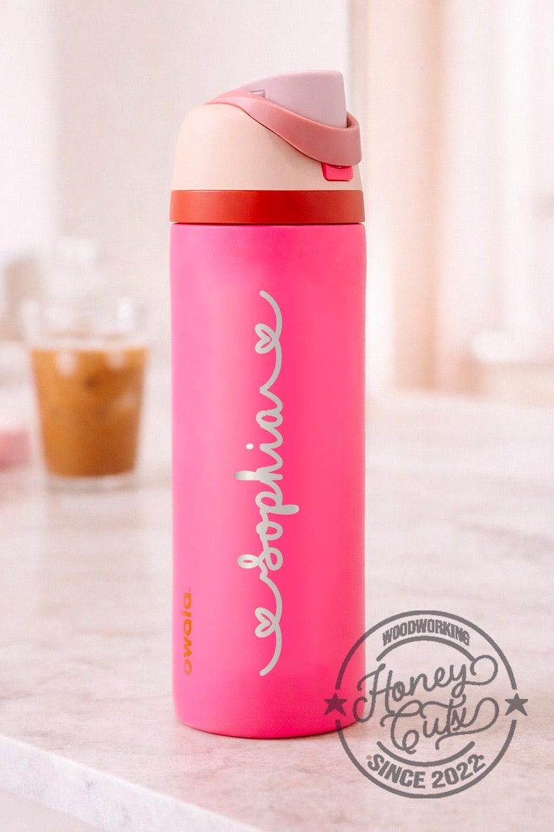 Op de afbeelding: Een felroze ge&iuml;soleerde waterfles met een lichtroze en rode deksel. De naam "Sophia" staat in een sierlijk lettertype op de zijkant. De fles heeft een inhoud van ongeveer 710 ml.