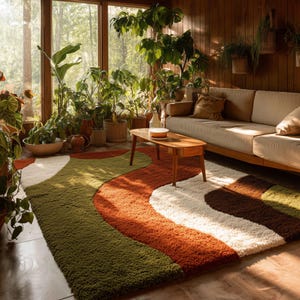 May include: A retro-style area rug with a wavy design in shades of green, orange, white, and brown. The rug is placed in a room with a wooden coffee table, a beige sofa, and many potted plants, creating a cozy, natural atmosphere.