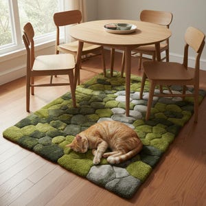 May include: A round wooden dining table with four matching chairs. A green and gray patterned rug is beneath the table and chairs. An orange tabby cat is sleeping on the rug.
