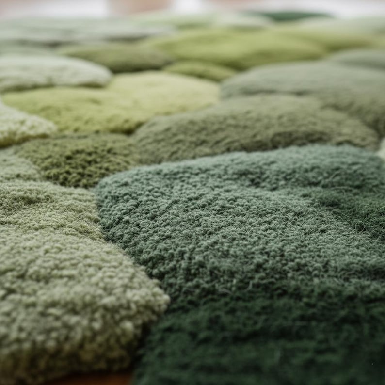 Close-up of the textured, hand-tufted wool pile of the organic-shaped green rug.