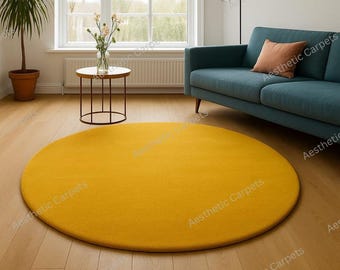 Puede incluir: Una alfombra redonda de color amarillo mostaza domina el primer plano de un salón. La alfombra está colocada sobre un suelo de madera clara. Al fondo, un sofá turquesa con un cojín color melocotón, una pequeña mesa auxiliar y una ventana.