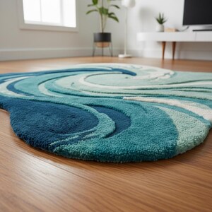 May include: A blue and teal area rug with a swirling wave design. The rug features varying shades of blue and teal, creating a textured, three-dimensional effect. The rug is placed on a wooden floor.