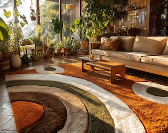 May include: A large, retro-style area rug with a rainbow design in shades of orange, brown, green, and white. The rug is placed in a sunlit room with a sofa, coffee table, and numerous potted plants, creating a warm and inviting atmosphere.
