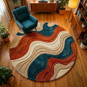 May include: A circular rug featuring a flowing design in terracotta, teal, and cream. The rug is positioned on a wooden floor, with a teal armchair visible. The rug's pattern provides a contemporary element to the room's furnishings.