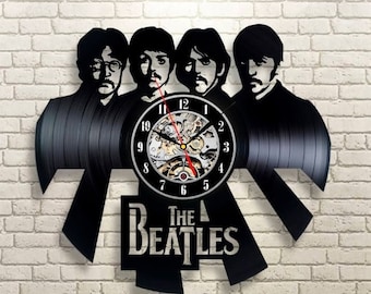 May include: Black vinyl record clock featuring the Beatles silhouette with the band's name and a clock face with Roman numerals.