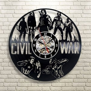 May include: Black vinyl record clock featuring characters from the Marvel movie "Civil War". The clock face is a white circle with black numbers and hands. The characters are silhouetted in black and include Captain America, Iron Man, Black Widow, Hawkeye, and Winter Soldier. The text "Civil War" is written in white on the clock face.
