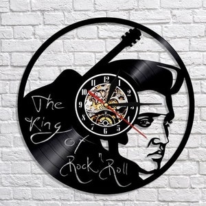 May include: Black vinyl record clock featuring a silhouette of Elvis Presley with a guitar and the text "The King of Rock 'n' Roll".