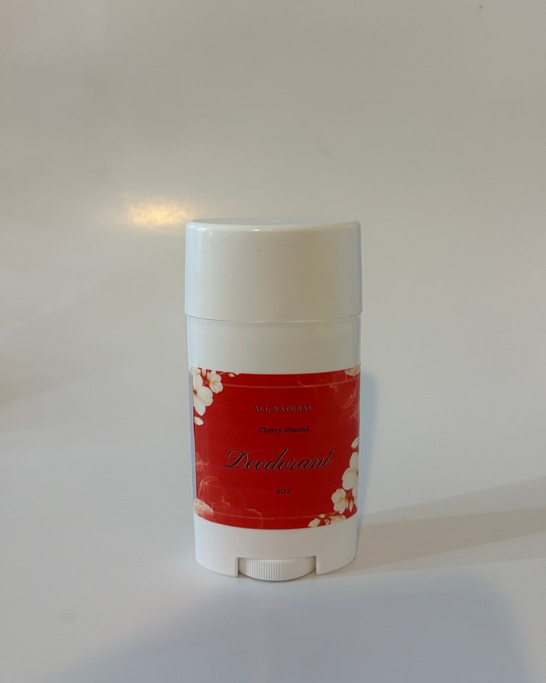 Puede incluir: Barra de desodorante blanca con una etiqueta roja que dice "All Natural Cherry Almond Deodorant 2 oz".