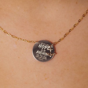 May include: A gold chain necklace with a silver pendant that reads "Hope is my anchor" and features a small anchor charm.