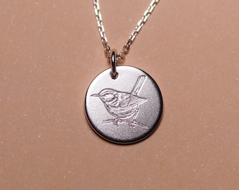 May include: A silver necklace with a round pendant featuring an engraved image of a small bird.